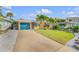 Charming one-story home with a well-maintained lawn, rock landscaping, and tall palm trees in the beautifully landscaped front yard at 308 Normandy Ave, New Smyrna Beach, FL 32169