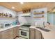 Charming kitchen features retro appliances, light wood ceiling, and white scale-patterned tile backsplash at 308 Normandy Ave, New Smyrna Beach, FL 32169