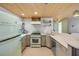 Charming kitchen features retro appliances, light wood ceiling, and white scale-patterned tile backsplash at 308 Normandy Ave, New Smyrna Beach, FL 32169