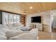 Bright living room with wood ceilings, neutral tones, and a large comfortable sofa with lots of natural light at 308 Normandy Ave, New Smyrna Beach, FL 32169