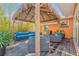 Inviting outdoor patio features a tiki-style gazebo, wood floors, and stylish, bright-blue cushions on comfortable outdoor furniture at 308 Normandy Ave, New Smyrna Beach, FL 32169