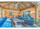 Inviting outdoor patio features a tiki-style gazebo, wood floors, and stylish, bright-blue cushions on comfortable outdoor furniture at 308 Normandy Ave, New Smyrna Beach, FL 32169