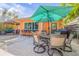 Outdoor patio with dining area, barbecue, and tiki bar with poolside views at 308 Normandy Ave, New Smyrna Beach, FL 32169