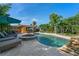 Relaxing backyard featuring a swimming pool, spa, lounge chairs, and lush greenery; perfect for relaxation and enjoyment at 308 Normandy Ave, New Smyrna Beach, FL 32169