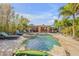 Resort-style backyard oasis featuring a sparkling pool, hot tub, tiki bar, and ample lounge space for entertaining at 308 Normandy Ave, New Smyrna Beach, FL 32169