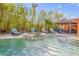 Backyard pool featuring a spa and tiki hut with bar and lush landscaping at 308 Normandy Ave, New Smyrna Beach, FL 32169