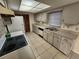 Efficient kitchen layout featuring white cabinetry, laminate countertops, and tiled floors at 309 & 311 Sea Hawk Ct, Edgewater, FL 32141