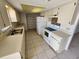 Functional kitchen with white appliances, ample cabinet storage, and tile flooring at 309 & 311 Sea Hawk Ct, Edgewater, FL 32141