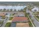 Aerial view shows single story home with tile roof, screened in porch, and community lake views at 3456 Pegaso Ave, New Smyrna Beach, FL 32168