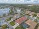 Aerial view shows single story home with tile roof, screened in porch, and community lake views at 3456 Pegaso Ave, New Smyrna Beach, FL 32168