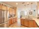 Eat-in kitchen boasts stainless steel appliances, wood cabinets, tile floors, and ample counter space at 3456 Pegaso Ave, New Smyrna Beach, FL 32168