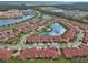 Aerial view of the community featuring well-maintained homes, a central lake, and lush greenery at 3546 Casalta Cir, New Smyrna Beach, FL 32168