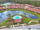 Stunning aerial view of a pool surrounded by a lake with homes in the background in a beautiful community at 3546 Casalta Cir, New Smyrna Beach, FL 32168