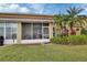 Backyard with a screened in patio, plush green grass, tropical landscaping and a peek of the pond at 3546 Casalta Cir, New Smyrna Beach, FL 32168
