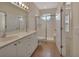 Bright bathroom featuring double sinks, a glass-enclosed shower, and a doorway leading to the bedroom at 3546 Casalta Cir, New Smyrna Beach, FL 32168