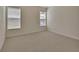 Bright bedroom featuring neutral carpet, baseboard trim, and two bright windows offering ample natural light at 3546 Casalta Cir, New Smyrna Beach, FL 32168