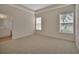 Carpeted bedroom with two windows and a view into the bathroom at 3546 Casalta Cir, New Smyrna Beach, FL 32168