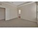 A bright bedroom with neutral walls and carpet, enhanced by a tray ceiling and view into the bathroom at 3546 Casalta Cir, New Smyrna Beach, FL 32168
