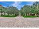 Brick paved walkway lined with lush green trees and landscaping in the community at 3546 Casalta Cir, New Smyrna Beach, FL 32168