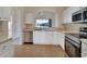 Well-lit kitchen featuring stainless steel appliances, white cabinets, and tile flooring at 3546 Casalta Cir, New Smyrna Beach, FL 32168