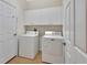A well-lit laundry room with white cabinets and modern washer and dryer at 3546 Casalta Cir, New Smyrna Beach, FL 32168