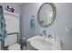 Well-lit bathroom featuring a pedestal sink with silver-tone faucet and an oval mirror above the sink at 3728 Egret Dunes Dr, Ormond Beach, FL 32176