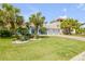 Stunning light blue home with lush lawn, brick driveway, and tropical landscaping at 3728 Egret Dunes Dr, Ormond Beach, FL 32176