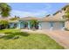 Charming light blue home with well-manicured lawn, brick driveway, and two-car garage at 3728 Egret Dunes Dr, Ormond Beach, FL 32176