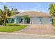 Charming light blue home with well-manicured lawn, brick driveway, and two-car garage at 3728 Egret Dunes Dr, Ormond Beach, FL 32176