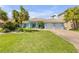 Beautiful light blue home with brick driveway, palm trees, and two-car garage at 3728 Egret Dunes Dr, Ormond Beach, FL 32176