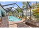 Relaxing screened pool area with chaise lounges, brick patio, and lush landscaping, perfect for leisure and entertainment at 3728 Egret Dunes Dr, Ormond Beach, FL 32176