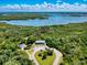 Breathtaking aerial view of home surrounded by lush trees, with beautiful blue water in the distance at 3800 Saxon Dr # 250, New Smyrna Beach, FL 32169