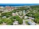 Neighborhood aerial view with lush trees and the ocean and beach in the distance at 3800 Saxon Dr # 250, New Smyrna Beach, FL 32169