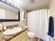 Cozy bathroom features a vanity with granite countertop, white shower curtain, and modern fixtures at 3800 Saxon Dr # 250, New Smyrna Beach, FL 32169