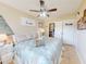 Comfortable bedroom with a blue and white comforter, ceiling fan, and beach decor at 3800 Saxon Dr # 250, New Smyrna Beach, FL 32169