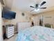 Bright bedroom with a ceiling fan, TV, and ample storage space in the white dresser at 3800 Saxon Dr # 250, New Smyrna Beach, FL 32169