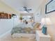 Inviting bedroom with a ceiling fan, tv, blue and white comforter and a bright window at 3800 Saxon Dr # 250, New Smyrna Beach, FL 32169
