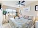 Bright bedroom features a ceiling fan, light colored walls and decor, and a large, sunny window at 3800 Saxon Dr # 250, New Smyrna Beach, FL 32169