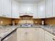 Updated kitchen with white cabinets, granite counters, and stainless steel appliances at 3800 Saxon Dr # 250, New Smyrna Beach, FL 32169