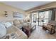 Cozy living room featuring a comfortable sofa, coffee table, and access to a balcony with outdoor seating at 3800 Saxon Dr # 250, New Smyrna Beach, FL 32169