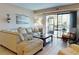 Bright living room featuring a comfortable couch and a sliding glass door at 3800 Saxon Dr # 250, New Smyrna Beach, FL 32169
