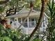 Charming cottage-style home with a screened porch, surrounded by lush tropical landscaping at 4426 Saxon Dr, New Smyrna Beach, FL 32169