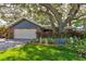 Lovely single Gathering home with a two car garage and a lush front yard with mature trees at 4426 Saxon Dr, New Smyrna Beach, FL 32169