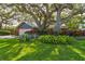 Lovely single Gathering home with a two car garage and a lush front yard with mature trees at 4426 Saxon Dr, New Smyrna Beach, FL 32169