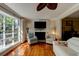 Bright living room featuring hardwood floors, a fireplace, and large windows for natural light at 4426 Saxon Dr, New Smyrna Beach, FL 32169