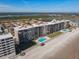 Beautiful aerial view of oceanfront condo building featuring pools, lush lawn, and beach access at 4445 S Atlantic Ave # 804, Ponce Inlet, FL 32127