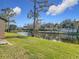 Scenic backyard view of a home featuring a serene pond and lush green lawn at 448 Shorewood Ln, New Smyrna Beach, FL 32168
