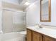 Full bathroom showcasing tile surround shower with glass doors, toilet, and sink with wood vanity and mirror at 448 Shorewood Ln, New Smyrna Beach, FL 32168