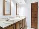 Large bathroom with dual sinks set in a wooden vanity, framed mirrors and a paneled door at 448 Shorewood Ln, New Smyrna Beach, FL 32168