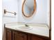 Bathroom with oak vanity, solid surface countertop, faucet, mirror, and towel bar at 448 Shorewood Ln, New Smyrna Beach, FL 32168